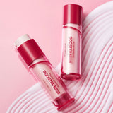 Two pink and white bottles of Plum Peptide Booster 2000s rest on a soft pink surface with curved textured lines on the right, creating a stylish and modern skincare display.