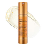 A gold bottle labeled Vita-Light Reedle Shot 100 stands upright before a clear gel smear with bubbles, hinting at a brightening Vitamin C skincare product. The bottle shows text and measurement markings.